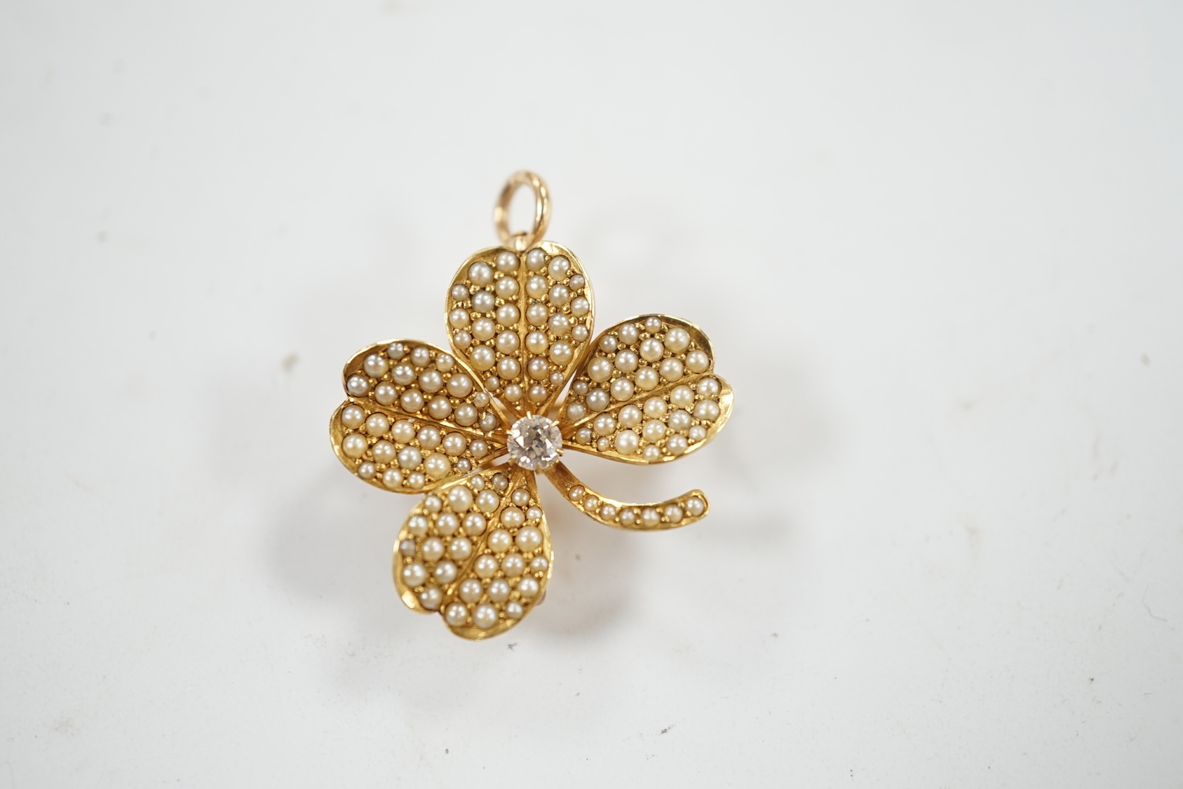 A 14k diamond and seed pearl set clover pendant brooch, width 21mm, gross weight 4.8 grams. Condition - fair to good